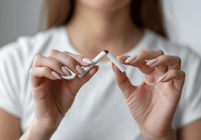Woman breaks cigarette in half signaling quitting smoking for CBD and nicotine study article.
