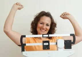 Successful menopause diet - woman smiles on scale